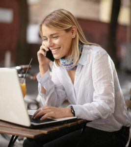 Smiling women making an online payment from mail while speaking on a call
